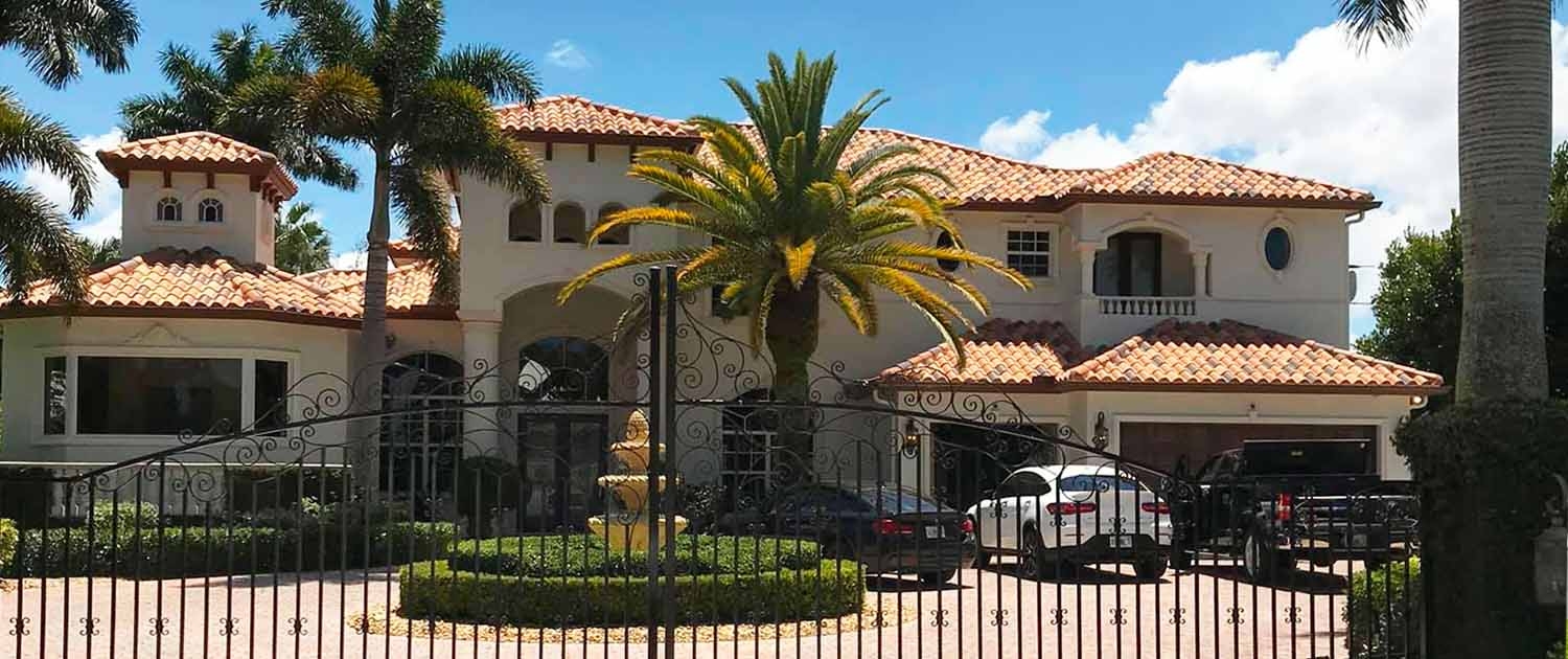 Completed South Florida home exterior with palm trees and a terracotta roof